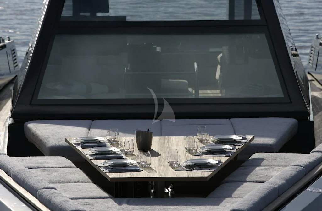 a table with a glass and a tray of food on it aboard ASH Yacht for Sale