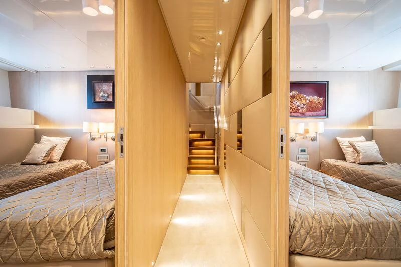 a room with two beds and a television on the wall aboard INDIGO Yacht for Sale