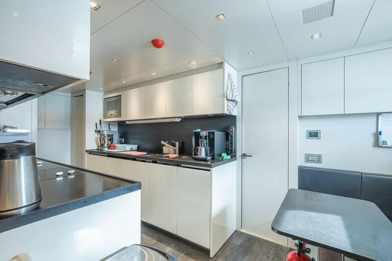 a kitchen with white cabinets aboard INDIGO Yacht for Sale