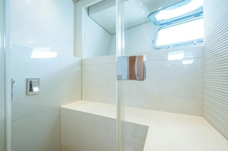 a white bathroom with a glass shower aboard INDIGO Yacht for Sale
