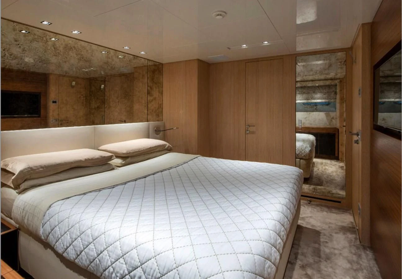 a room with a bed and a wood door aboard INDIGO Yacht for Sale