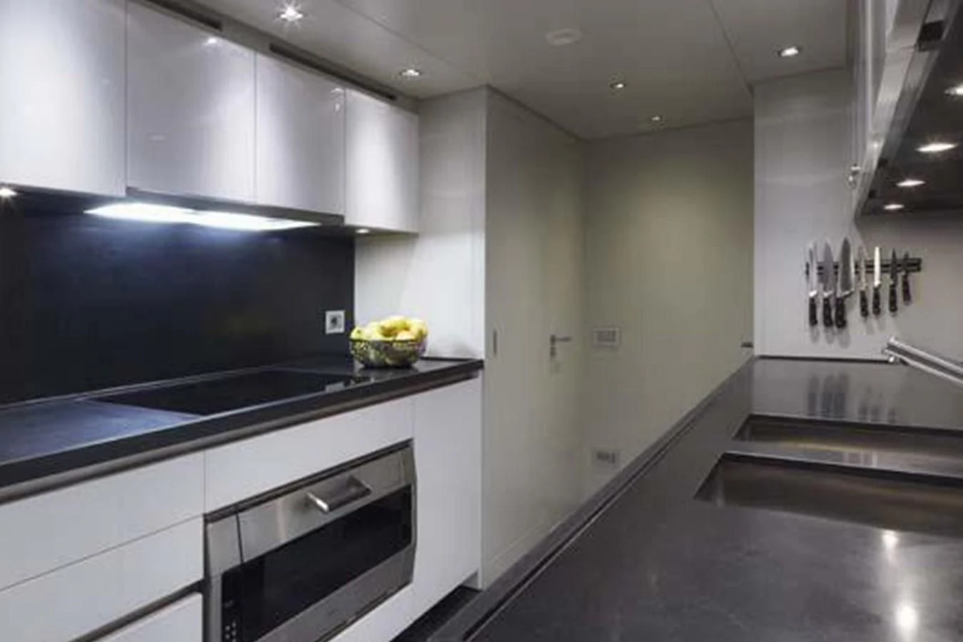 a kitchen with black appliances aboard INDIGO Yacht for Sale