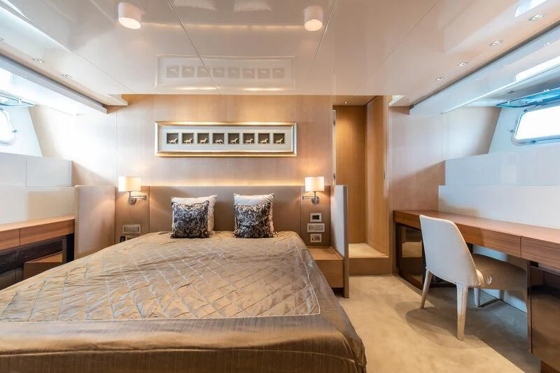 a hotel room with a bed and desk aboard INDIGO Yacht for Sale