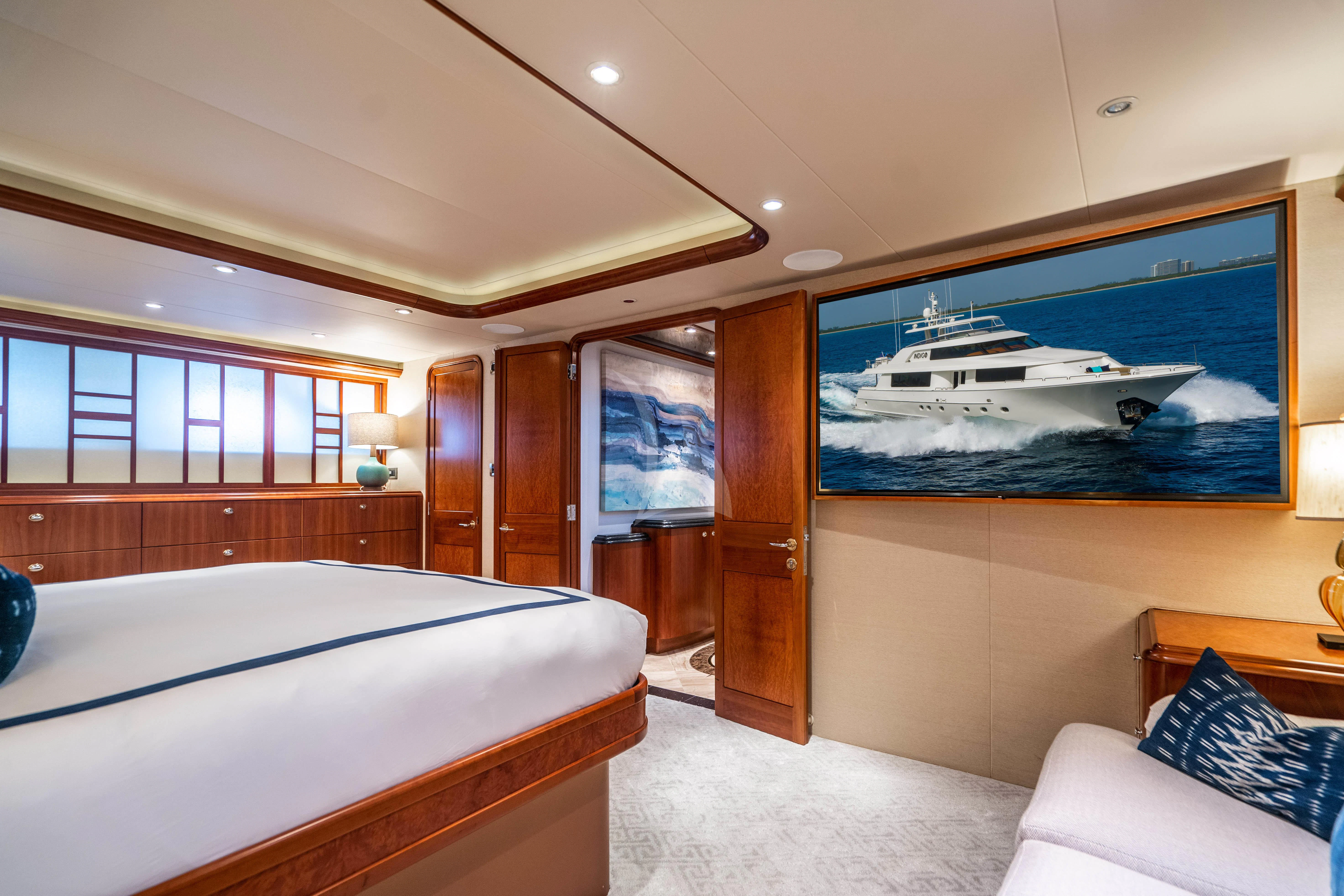 a bedroom with a large television aboard INDIGO Yacht for Sale