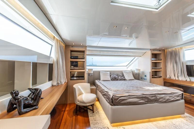 a bedroom with a bed and a chair aboard INDIGO Yacht for Sale