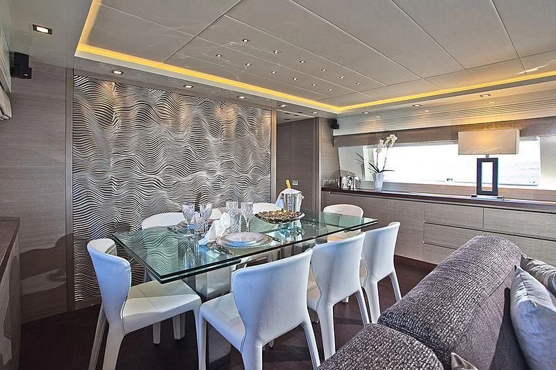 a dining table with chairs and a large window aboard DADDY'S DREAM 888 Yacht for Charter
