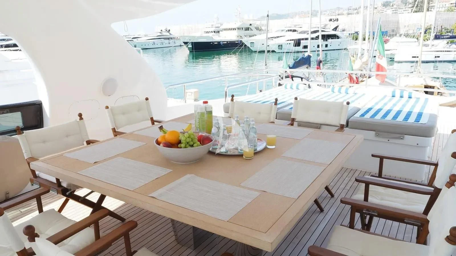 a table with a bowl of fruit on it next to a boat aboard DADDY'S DREAM 888 Yacht for Charter