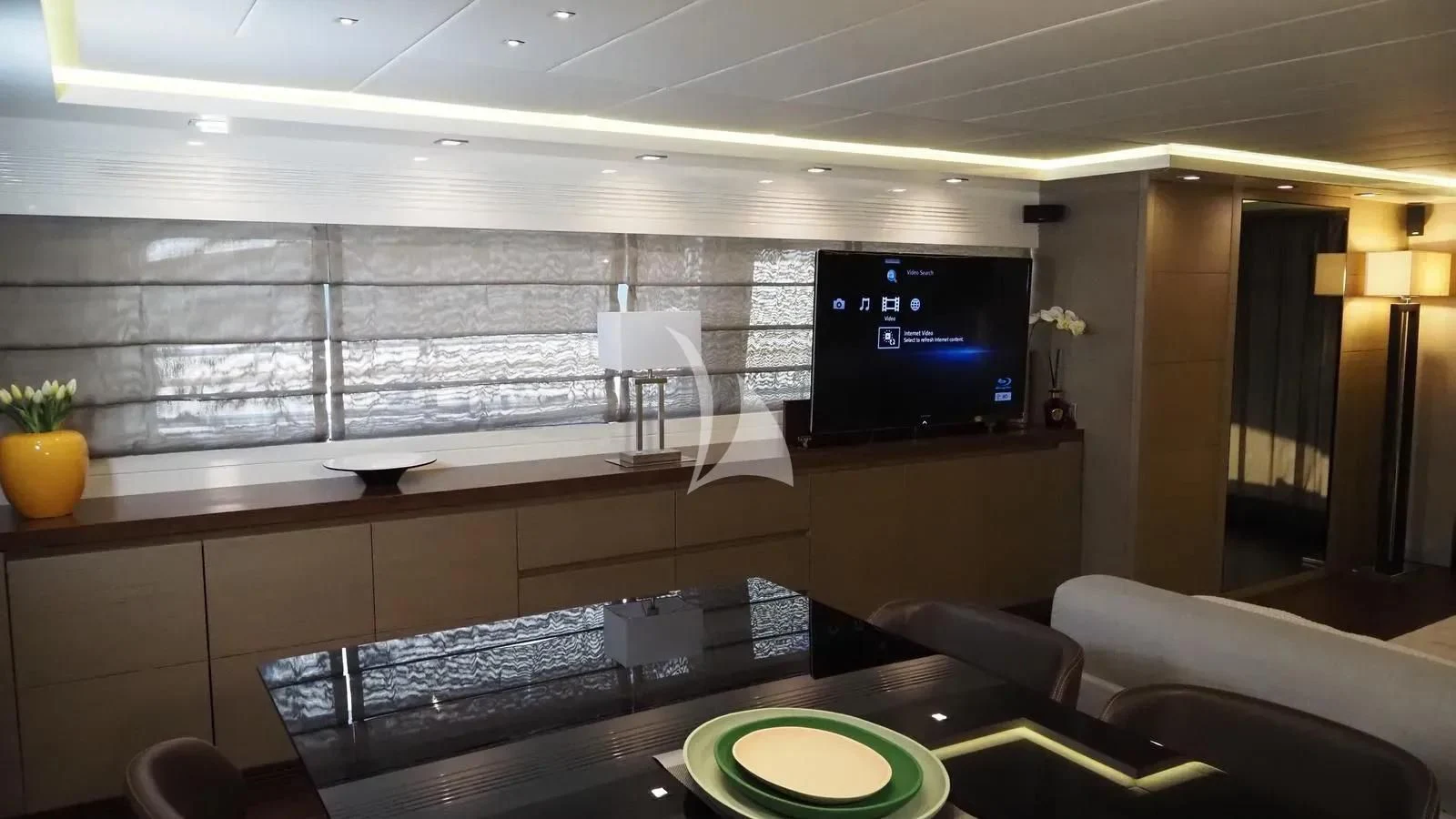 a room with a tv and a table aboard DADDY'S DREAM 888 Yacht for Charter