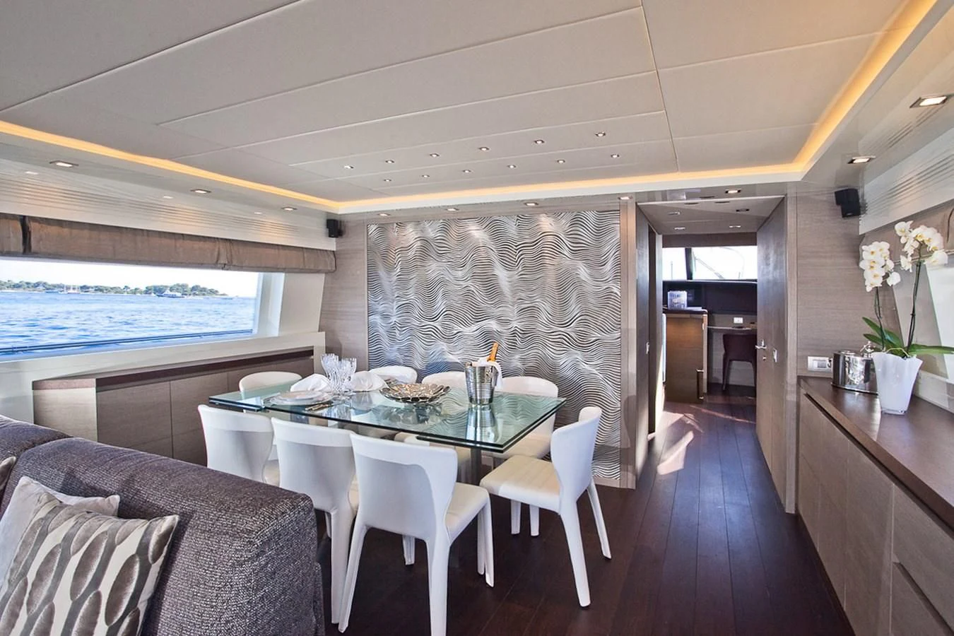 a dining table and chairs in a room with a large body of water aboard DADDY'S DREAM 888 Yacht for Charter