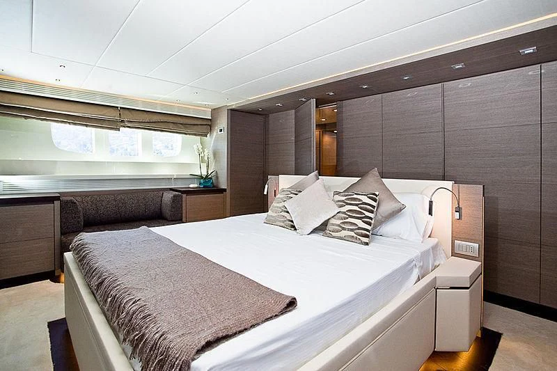 a room with a bed and a chair aboard DADDY'S DREAM 888 Yacht for Charter