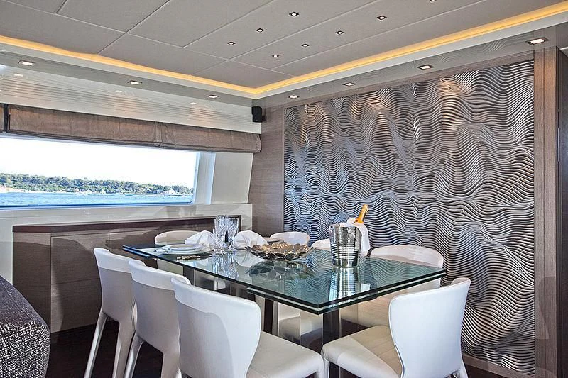 a dining table with chairs and a view of the water aboard DADDY'S DREAM 888 Yacht for Charter