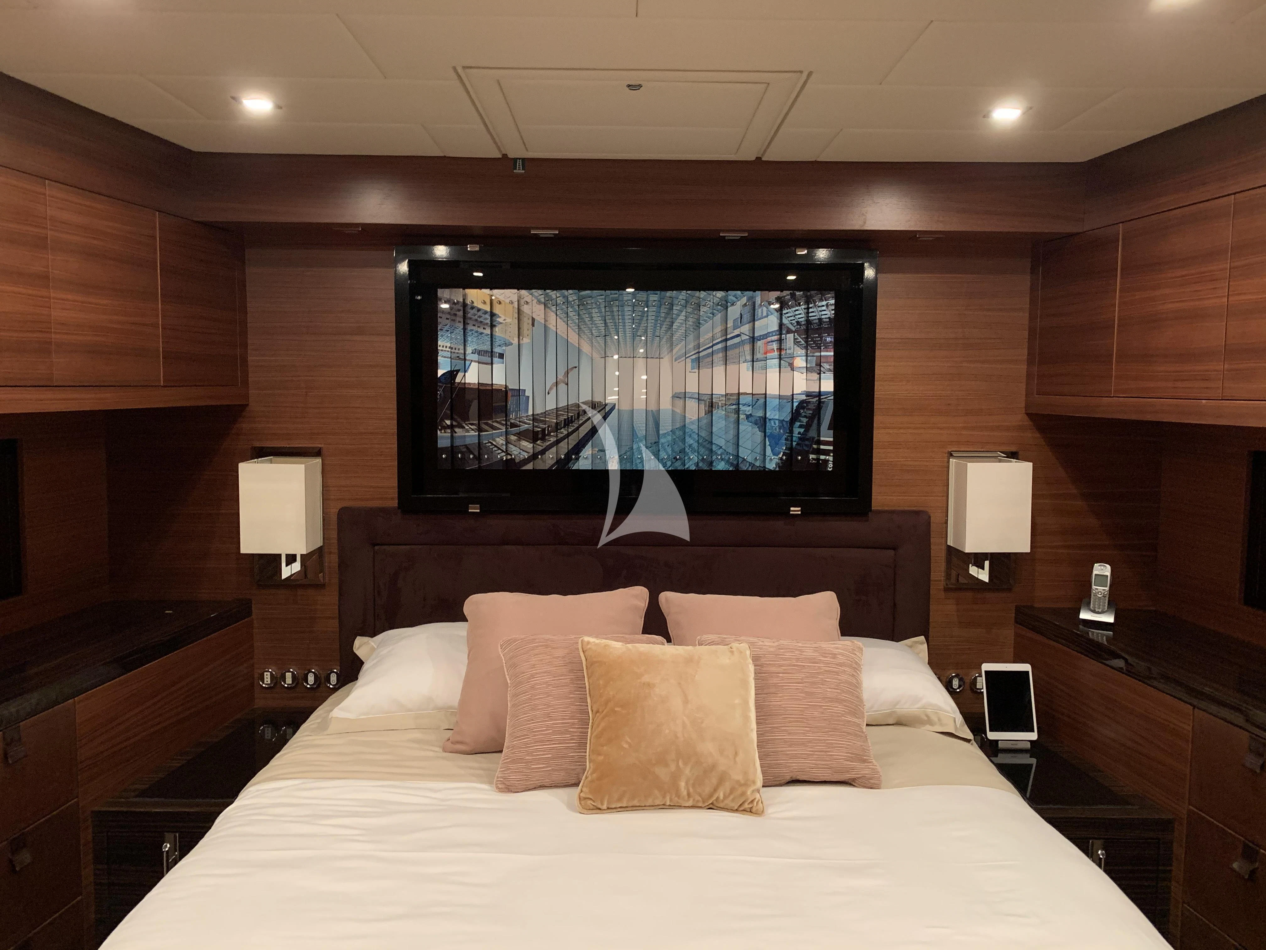 a bed with pillows and a tv in a room aboard ECLAT Yacht for Sale