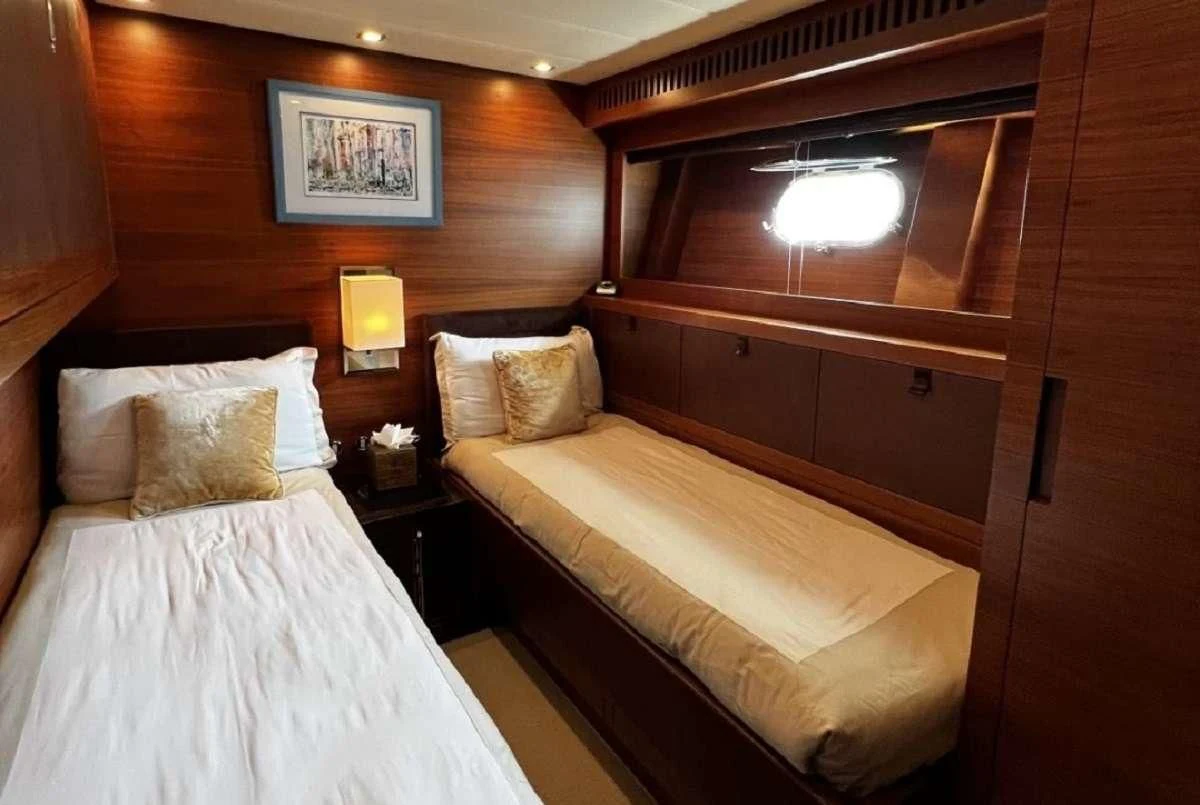 a room with a bed and a night stand aboard ECLAT Yacht for Sale