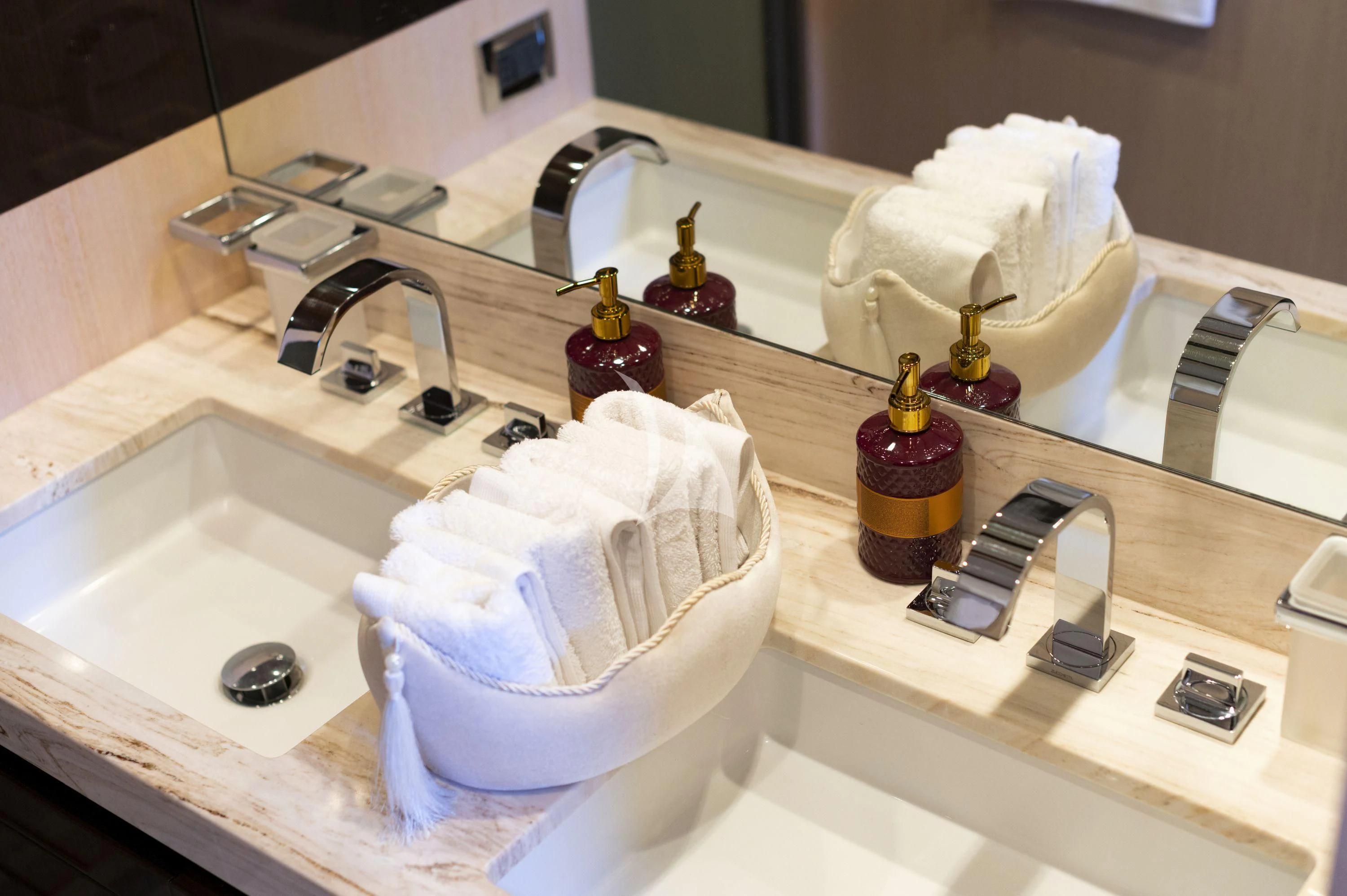 a bathroom sink with a towel and soap dispenser aboard HUBO Yacht for Sale