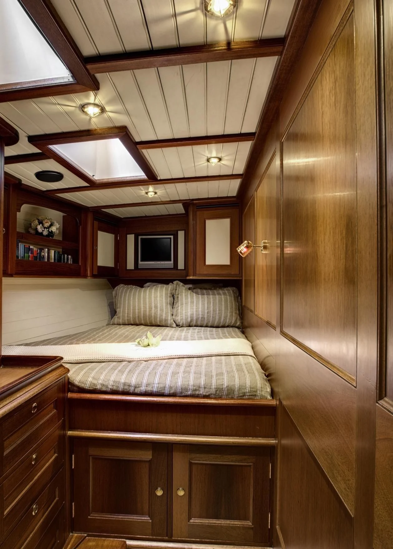 a room with a bed and a shelf with books on it aboard SHAMOUN Yacht for Sale