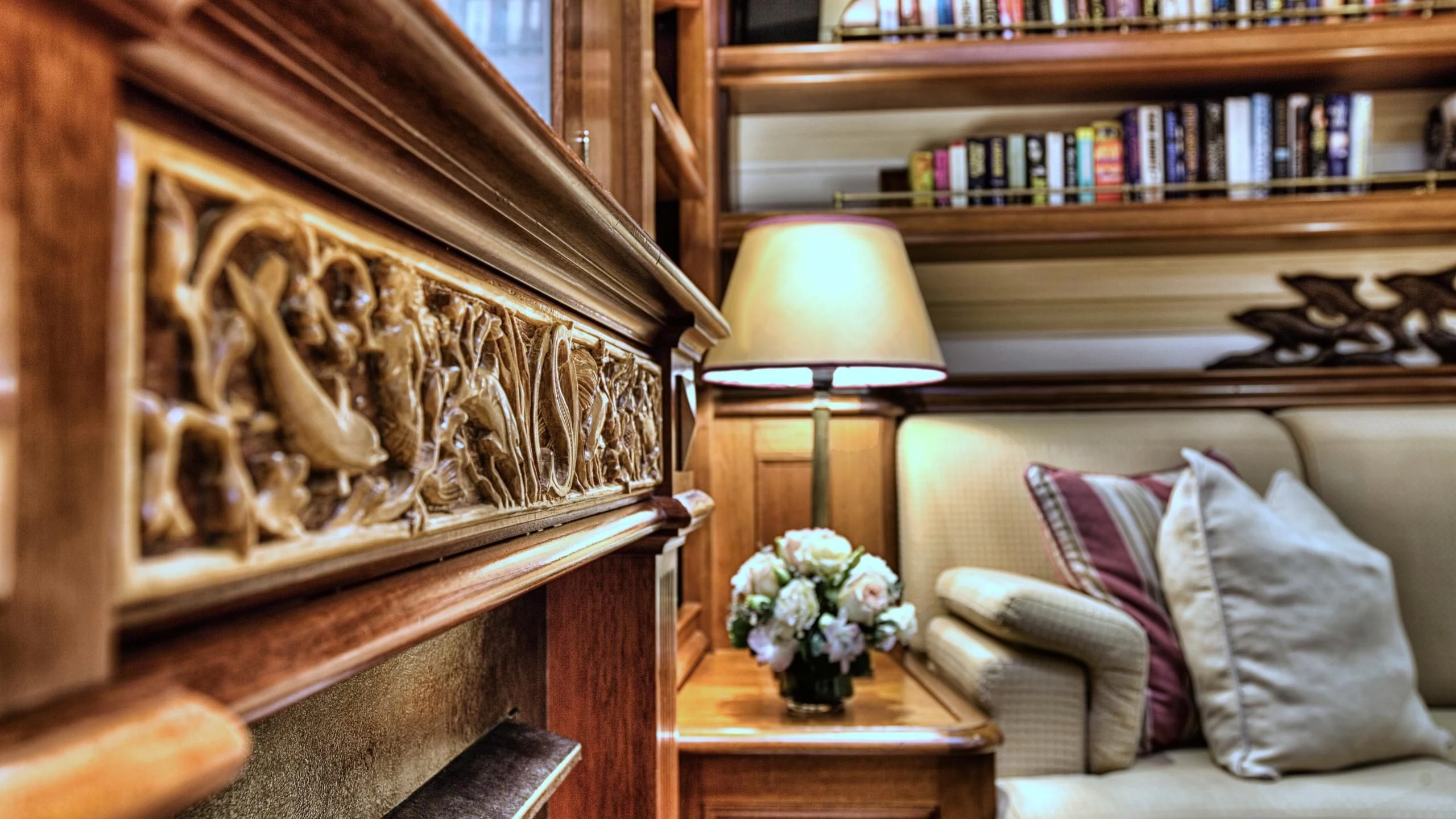 a room with a couch and a lamp and a bookcase aboard SHAMOUN Yacht for Sale
