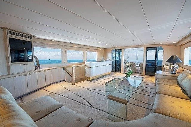 a living room with a glass coffee table and a view of the city aboard IVORY LADY Yacht for Sale