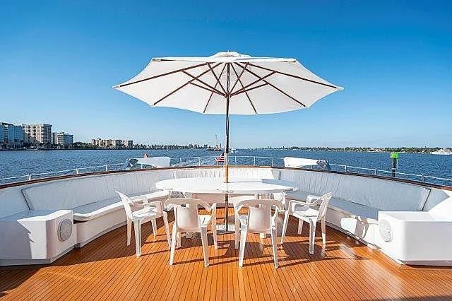 a table and chairs on a deck overlooking a beach aboard IVORY LADY Yacht for Sale