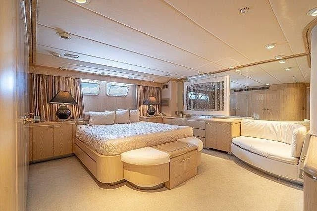 a large bedroom with a bed and a desk aboard IVORY LADY Yacht for Sale