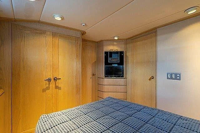 a room with a table and a tv aboard IVORY LADY Yacht for Sale