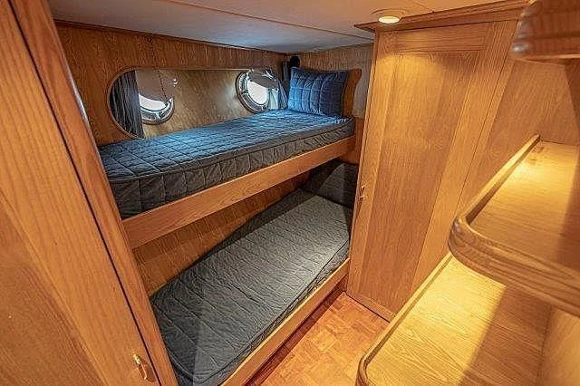 a bed with a blue cover aboard IVORY LADY Yacht for Sale