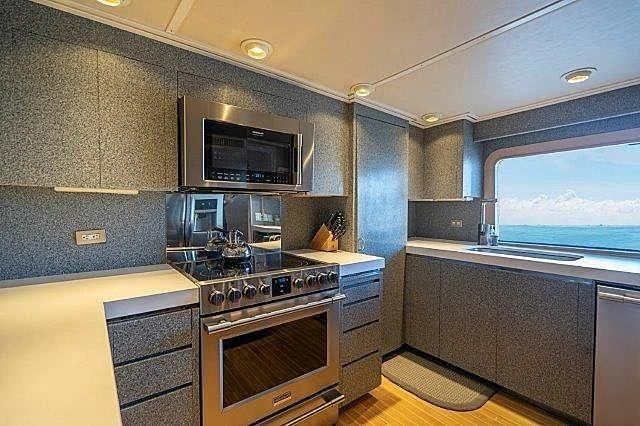 a kitchen with a stove and microwave aboard IVORY LADY Yacht for Sale