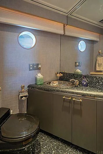 a bathroom with a sink and a round mirror aboard IVORY LADY Yacht for Sale