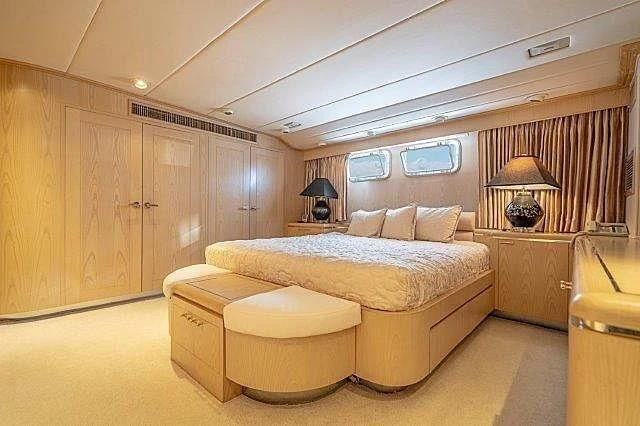 a bedroom with a bed and a desk aboard IVORY LADY Yacht for Sale