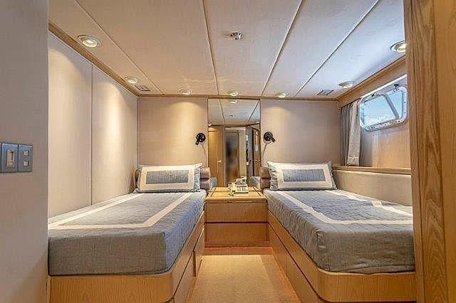 a room with beds and a window aboard IVORY LADY Yacht for Sale