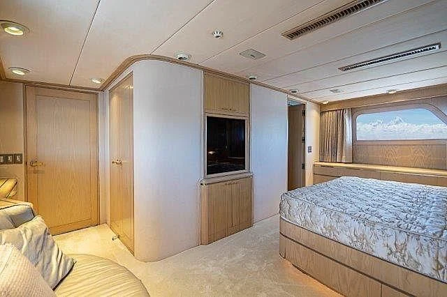 a bedroom with a bed and a window aboard IVORY LADY Yacht for Sale