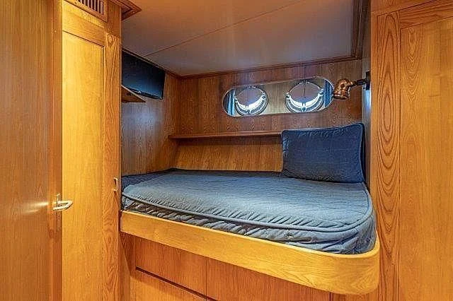a bed with a blue pillow aboard IVORY LADY Yacht for Sale