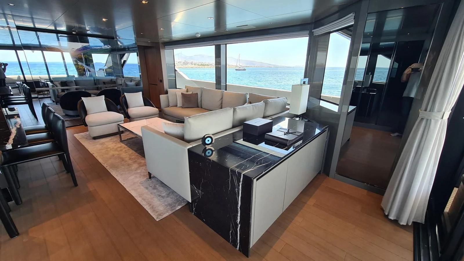 a room with a large window and a table with chairs and a large window aboard 2021 SANLORENZO SD96 #95 Yacht for Sale