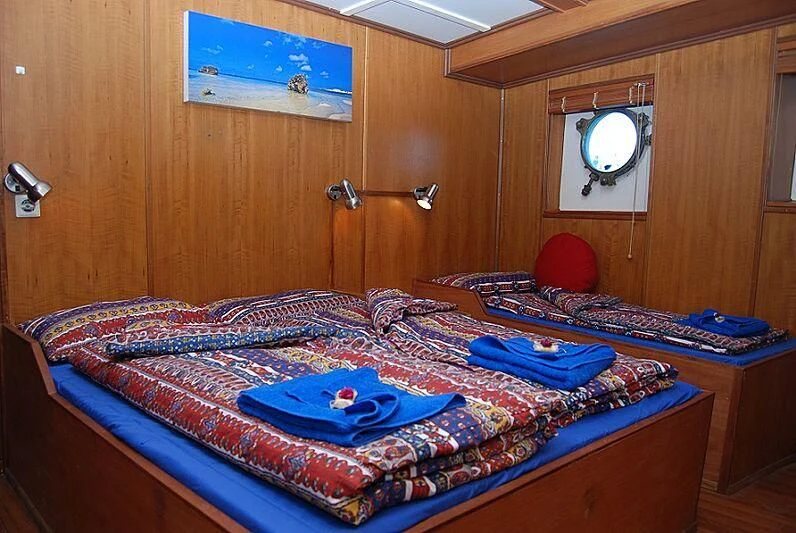 a bed with a red balloon aboard MAYA'S DUGONG Yacht for Sale