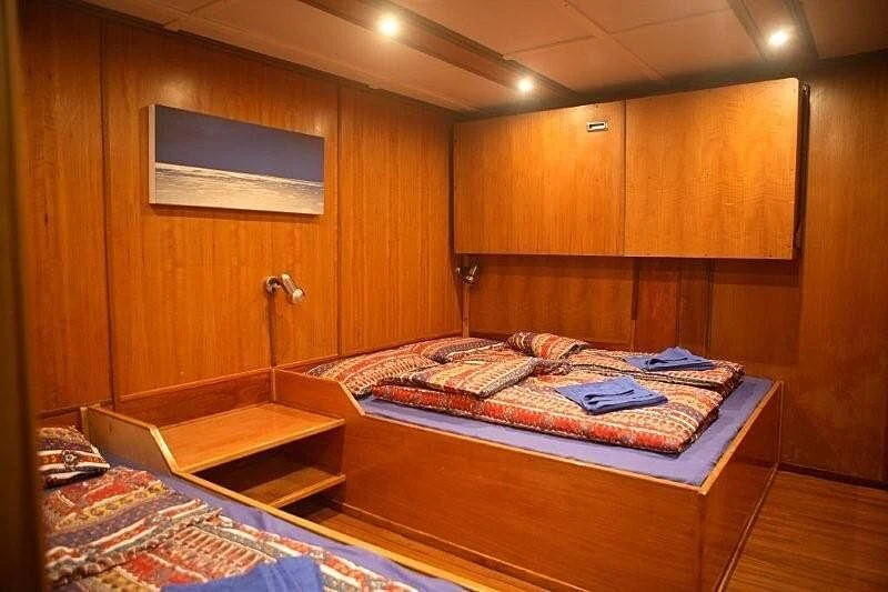 a room with a couple of beds aboard MAYA'S DUGONG Yacht for Sale