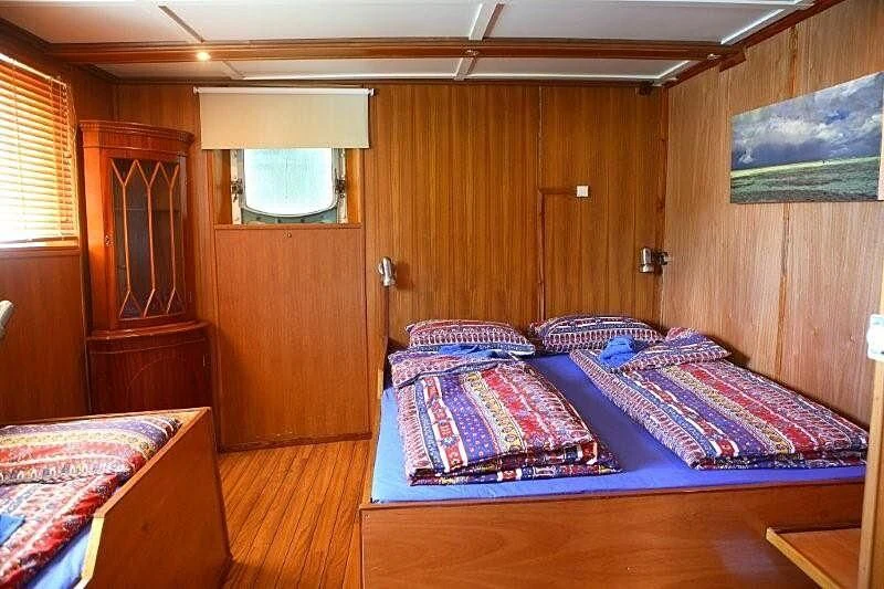 a bedroom with a bed and a door aboard MAYA'S DUGONG Yacht for Sale
