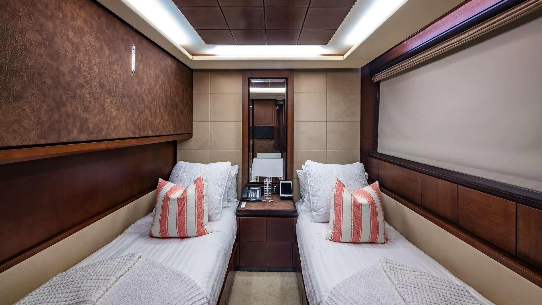 a room with beds and a mirror aboard TAIL LIGHTS Yacht for Sale