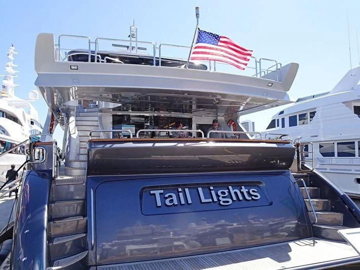 a boat with a flag on the front aboard TAIL LIGHTS Yacht for Sale