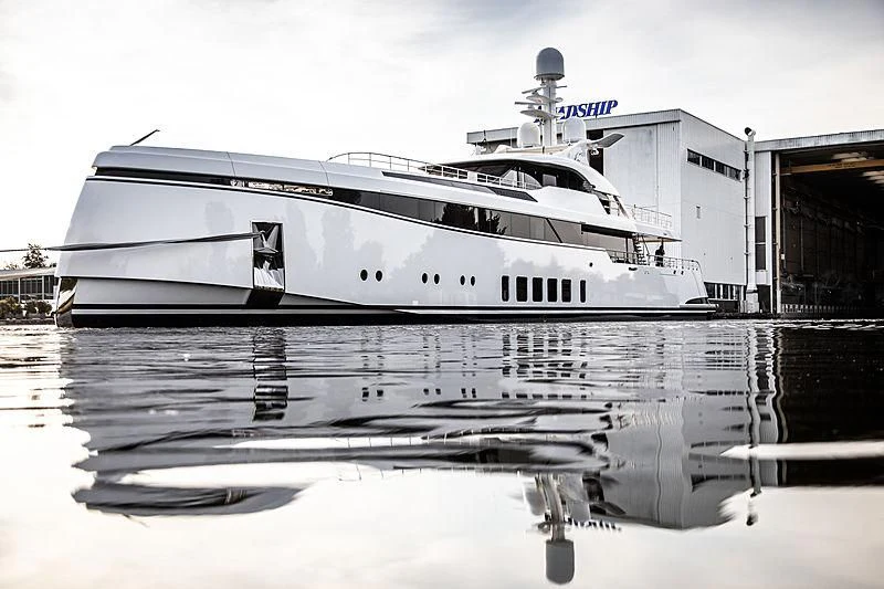 a white yacht docked at a pier aboard TOTALLY NUTS Yacht for Sale
