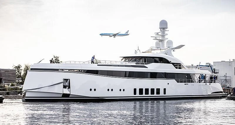 a large white yacht with a plane flying over it aboard TOTALLY NUTS Yacht for Sale