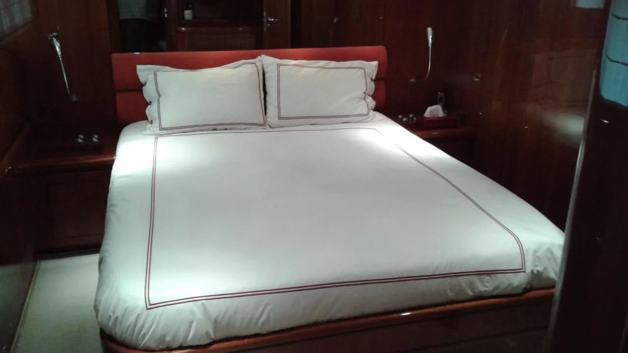 a bed with white sheets aboard PRINCESS AYESHA I Yacht for Sale