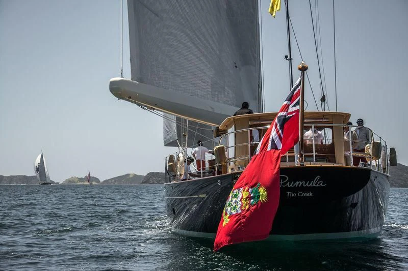 a boat with a flag on it aboard PUMULA Yacht for Sale