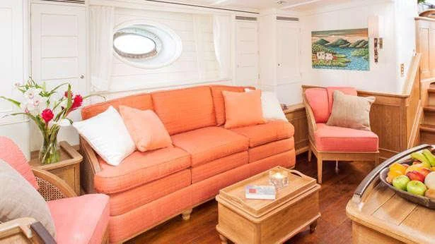 a living room with a couch and a table aboard PUMULA Yacht for Sale