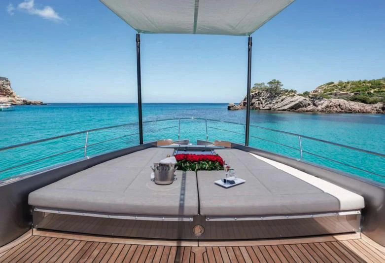 a balcony with a table and a plant on it aboard XAMAN Yacht for Sale