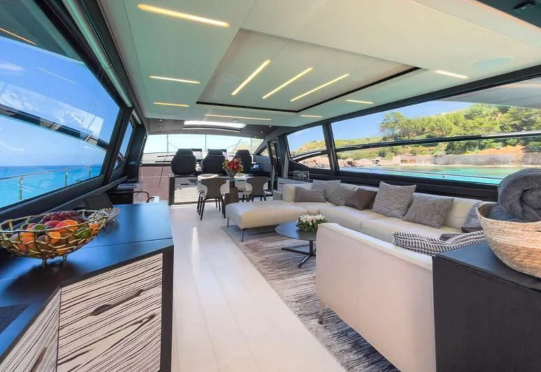 inside of a vehicle with a couch and a table and chairs aboard XAMAN Yacht for Sale