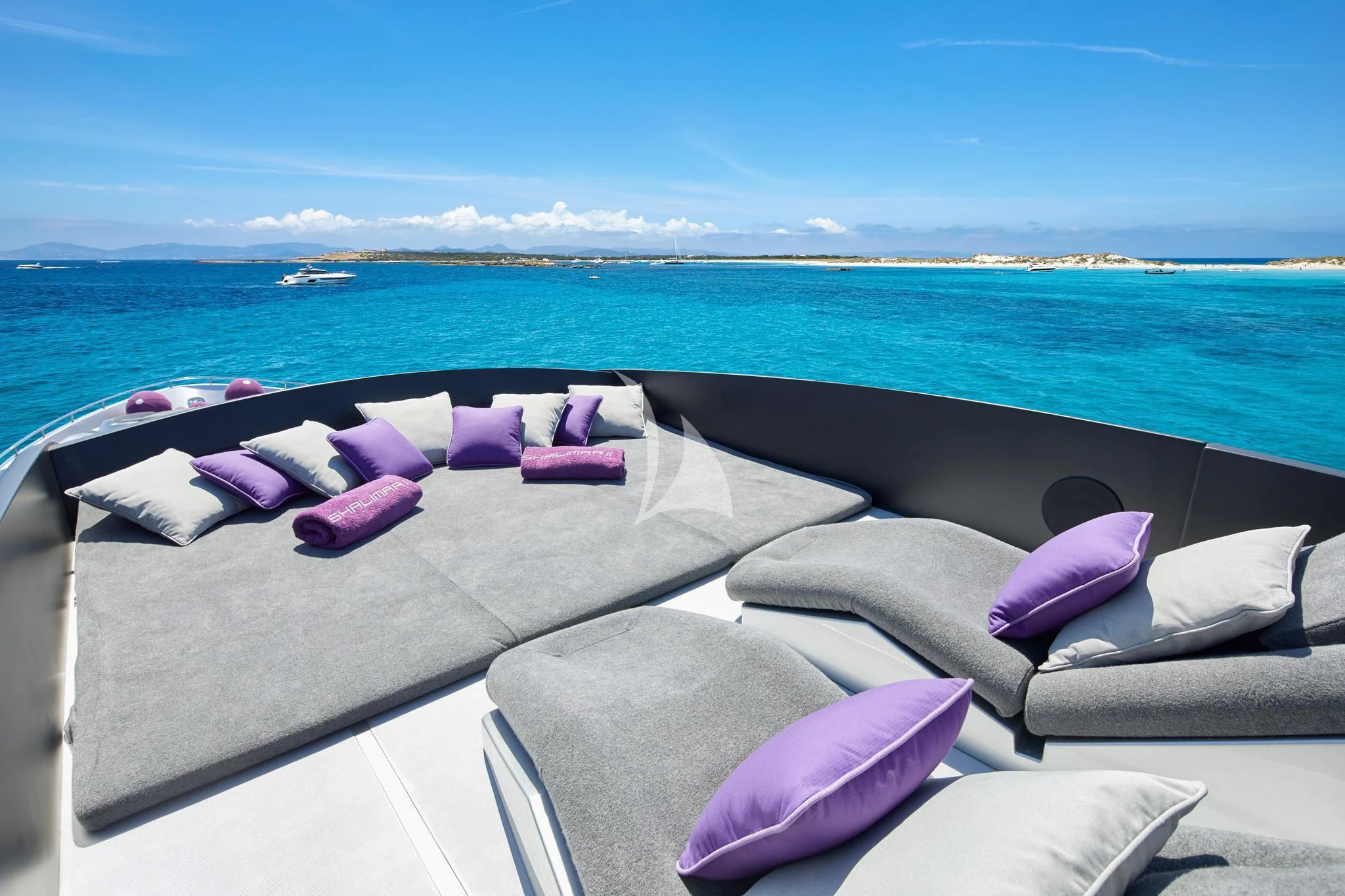 a couch with pillows on it by the ocean aboard XAMAN Yacht for Sale