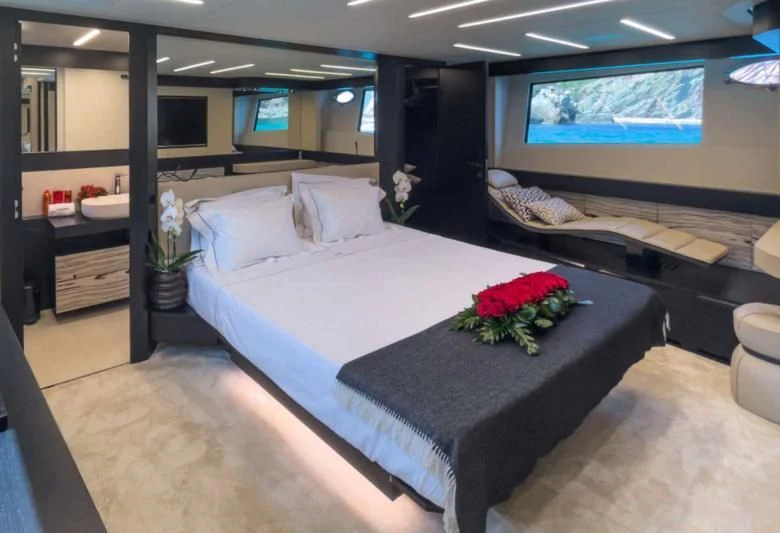 a room with a bed and a tv on the wall aboard XAMAN Yacht for Sale