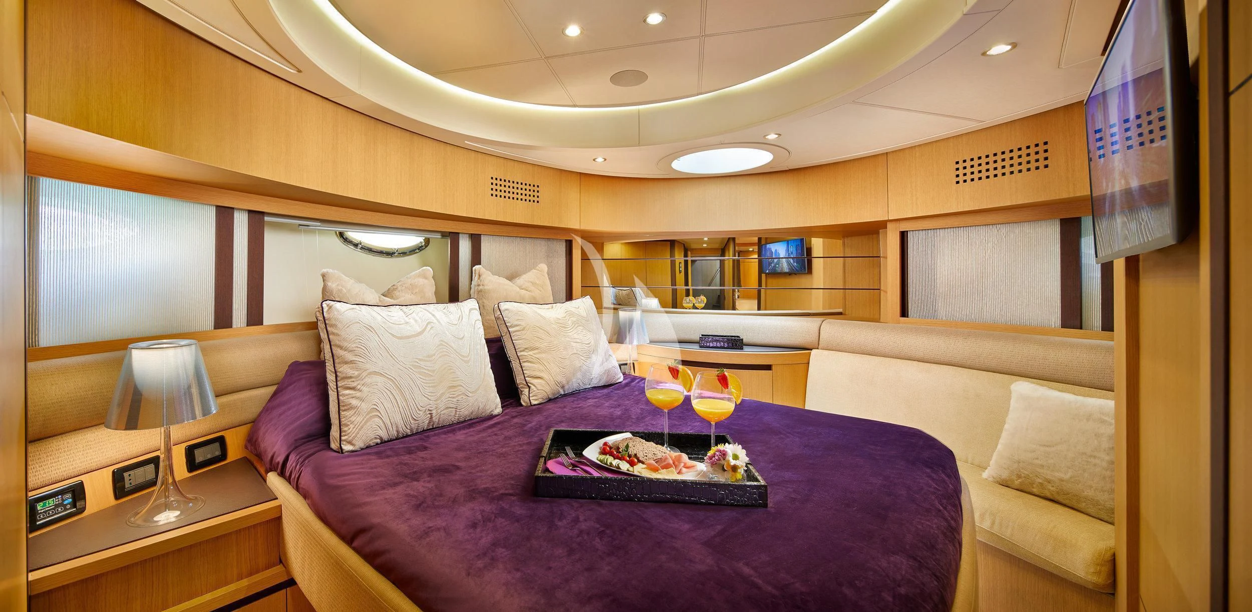 a bed with purple sheets and pillows aboard XAMAN Yacht for Sale