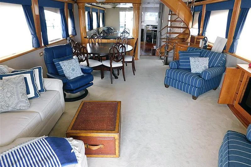 a living room with a blue couch and a table aboard MOONSHINE Yacht for Sale