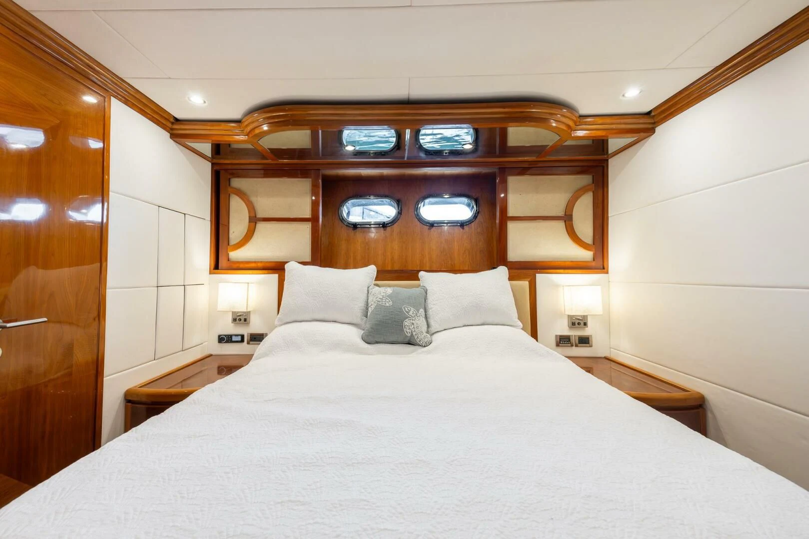 a bed with pillows and a mirror above it aboard OCEAN 1 Yacht for Sale