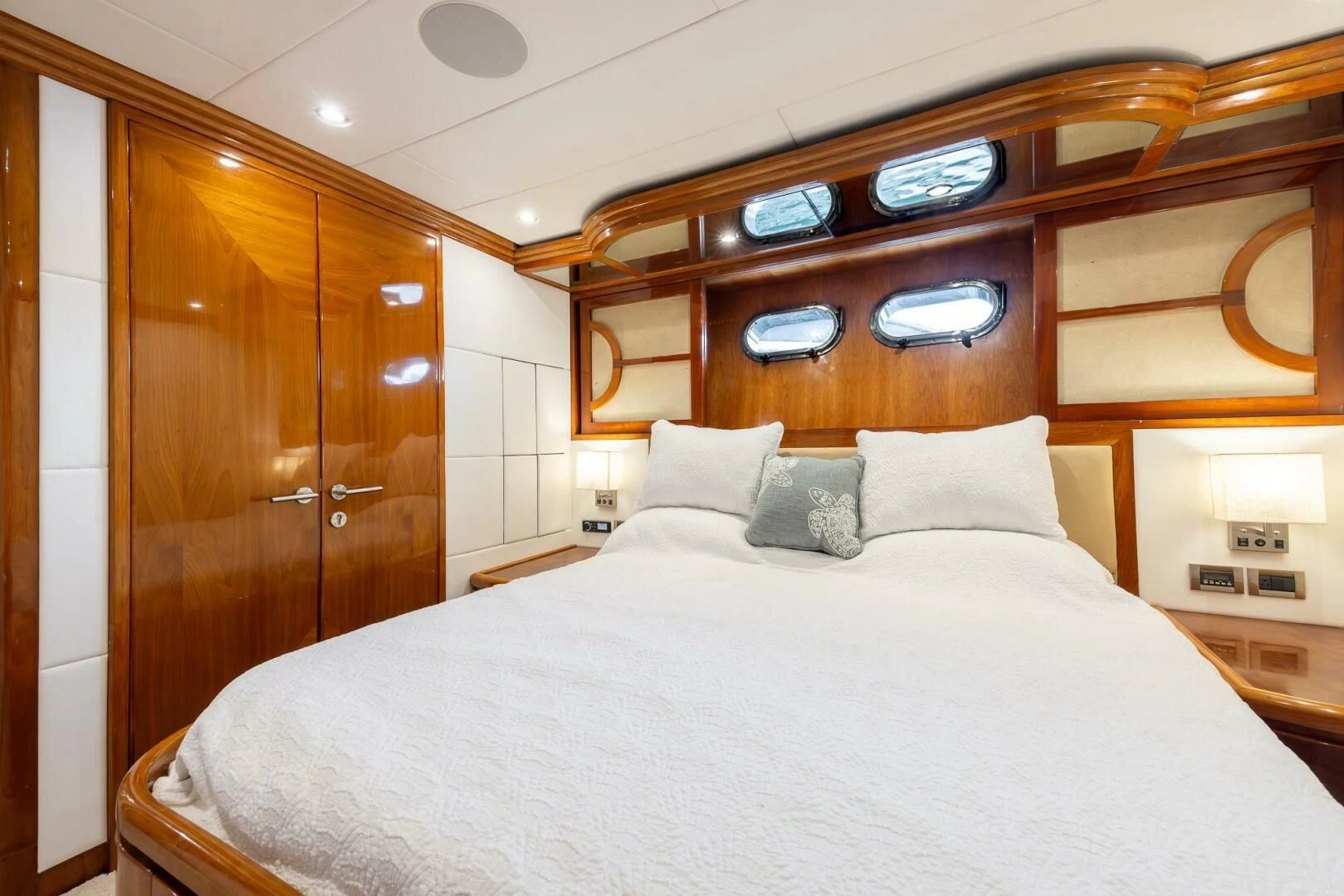 a bed with pillows and a mirror above it aboard OCEAN 1 Yacht for Sale